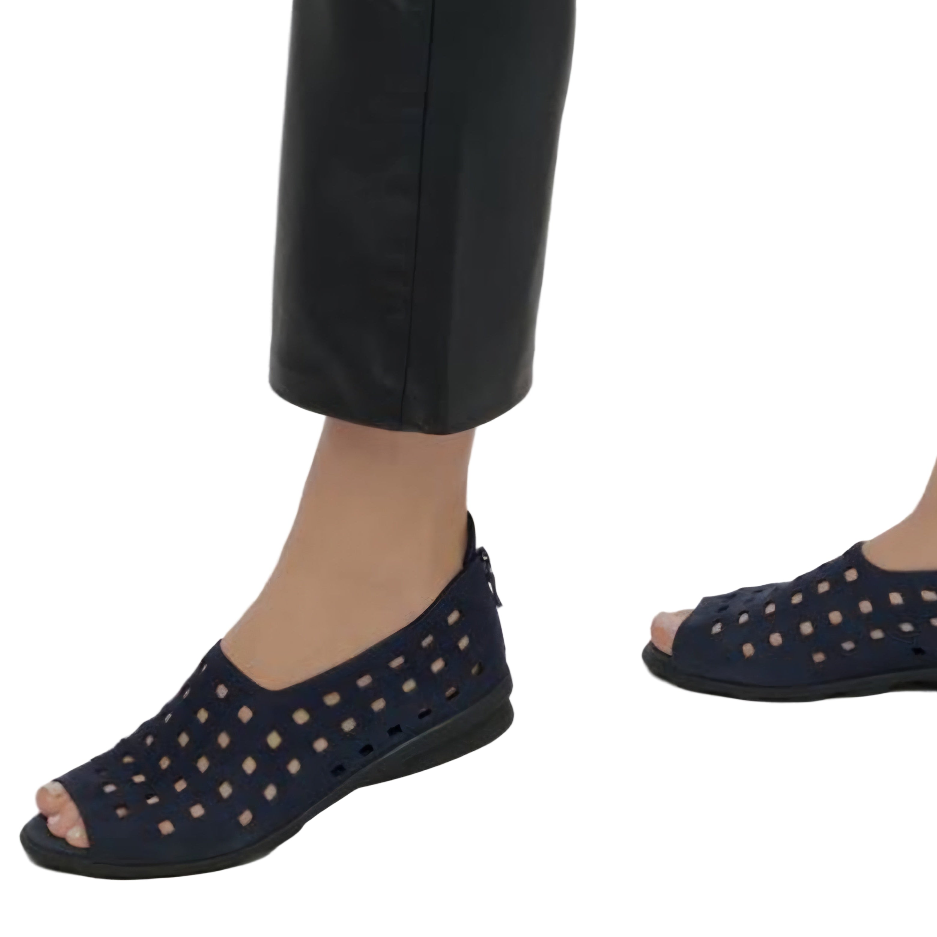 Navy perforated sandals worn with black pants on a light gray background